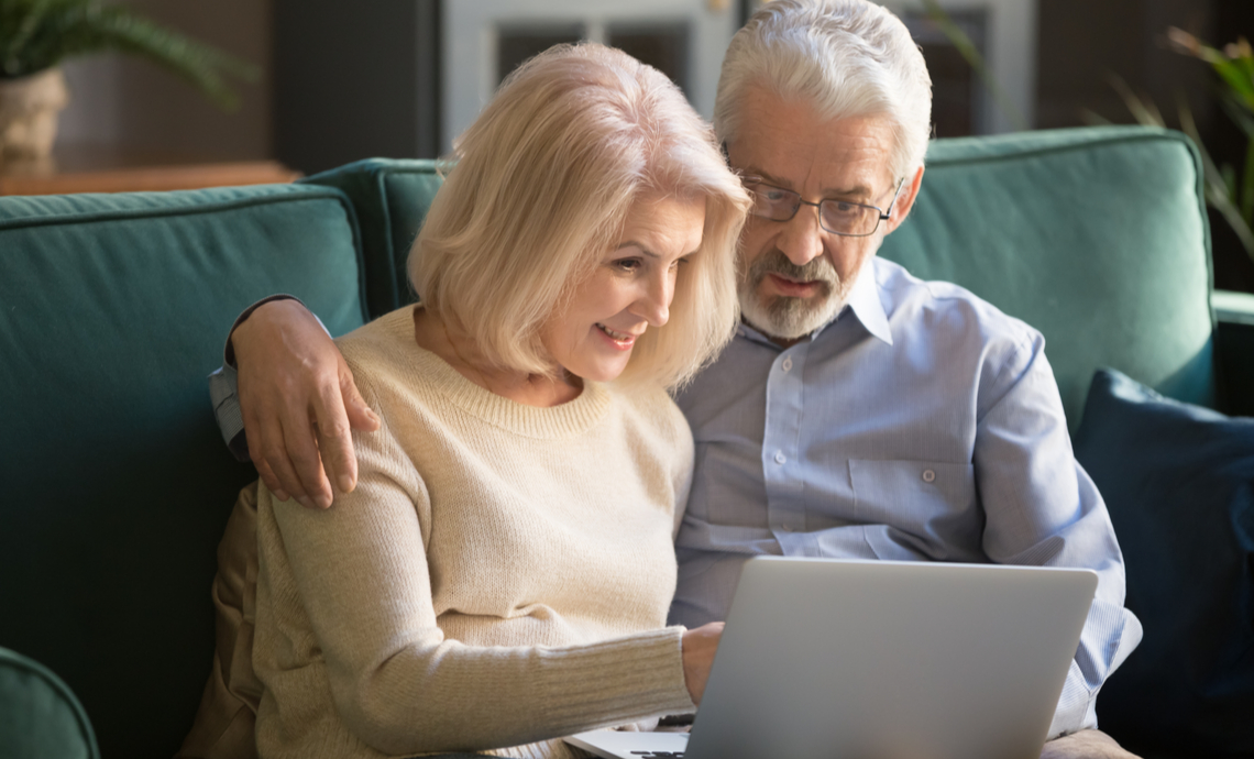 Older couple looking at a laptop comparing insurance options