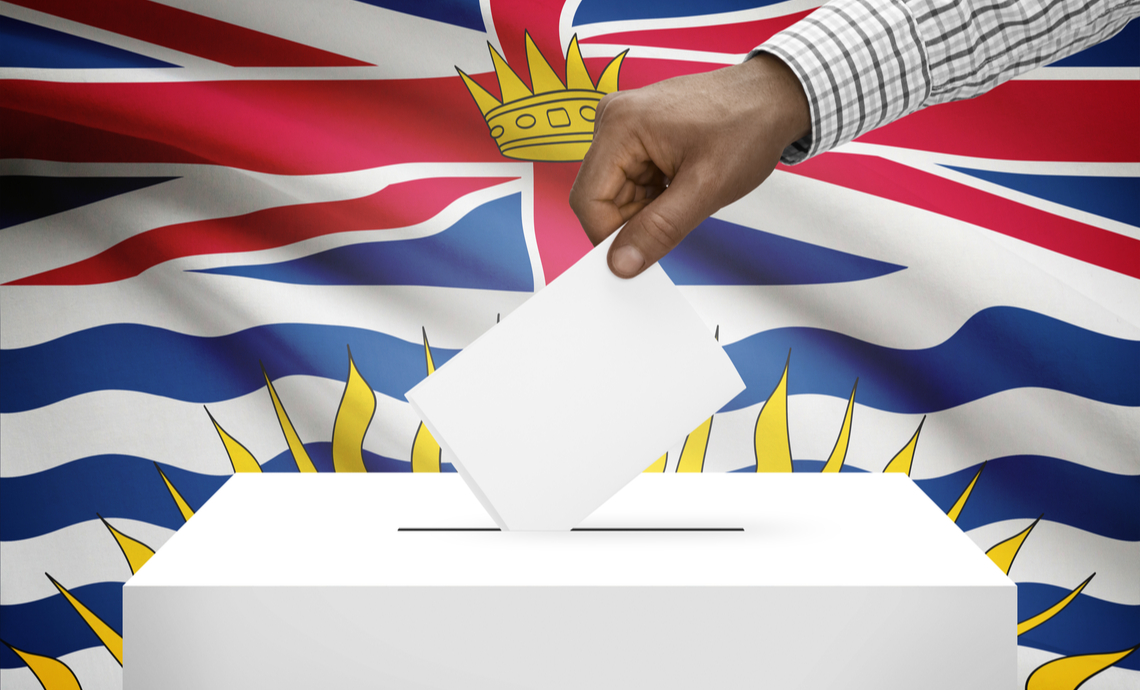 Hand holding ballot above a ballot box in B.C.