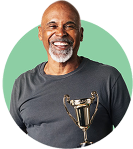 Smiling retiree in a workout top holding a trophy