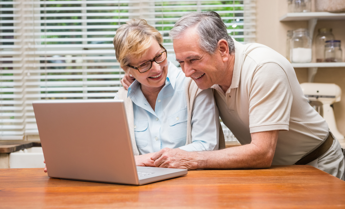 couple âgé examinant ses finances sur un ordinateur portable