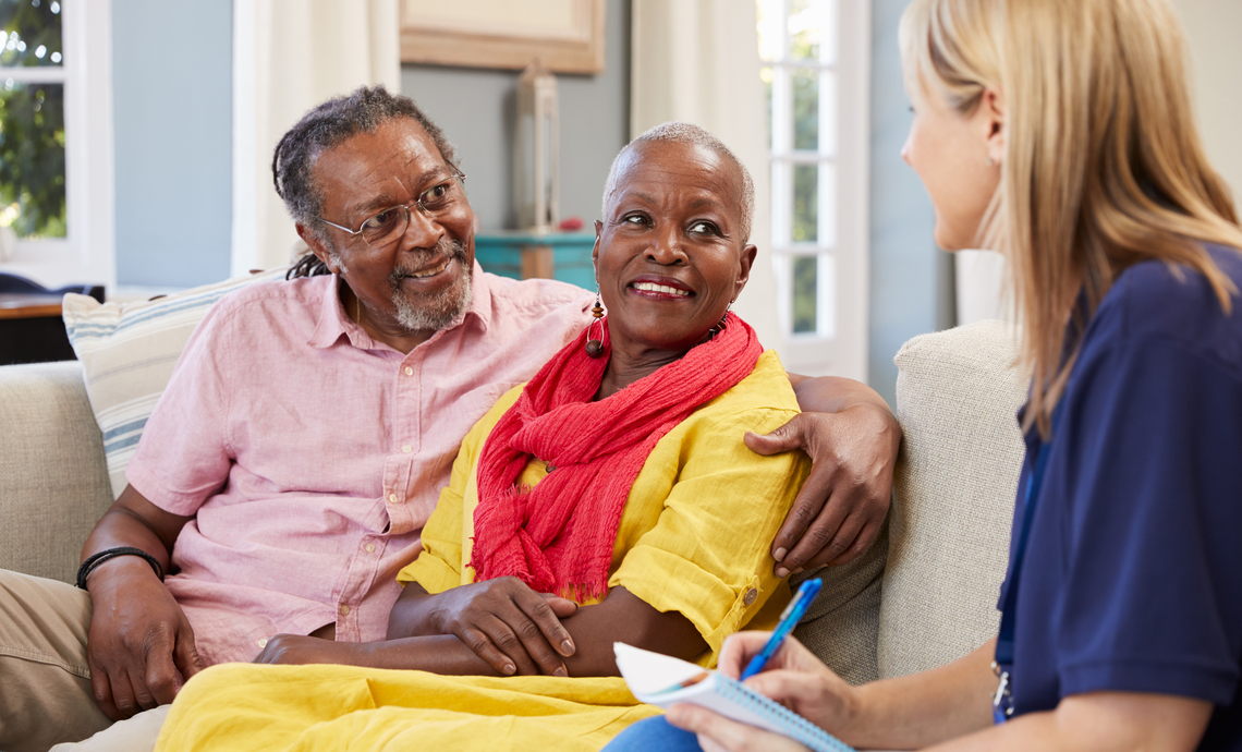 Older couple in their home talking to a support worker