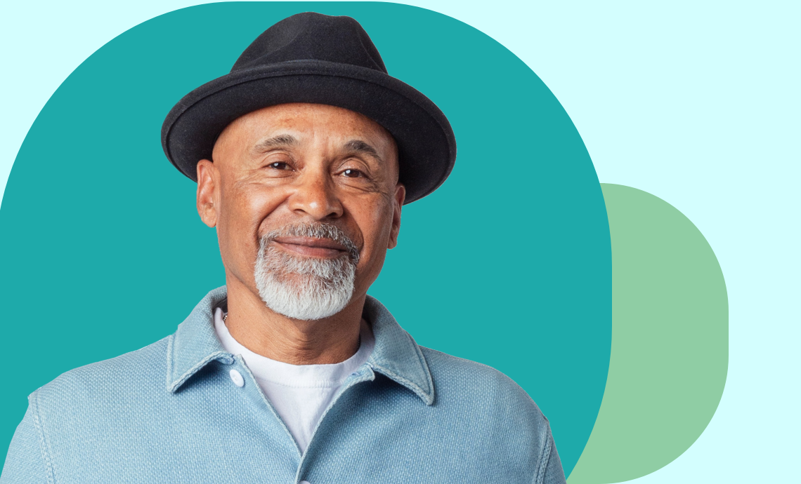 smiling retiree wearing a hat against a turquoise background